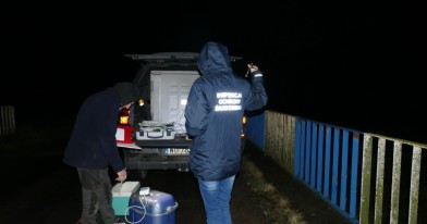 Inspektorzy ochrony Środowiska podczas czynności służbowych, wraz z pracownikami Centralnego Laboratorium Badawczego pobierają próbki zanieczyszczonej wody w rzece  i wykonują badanie