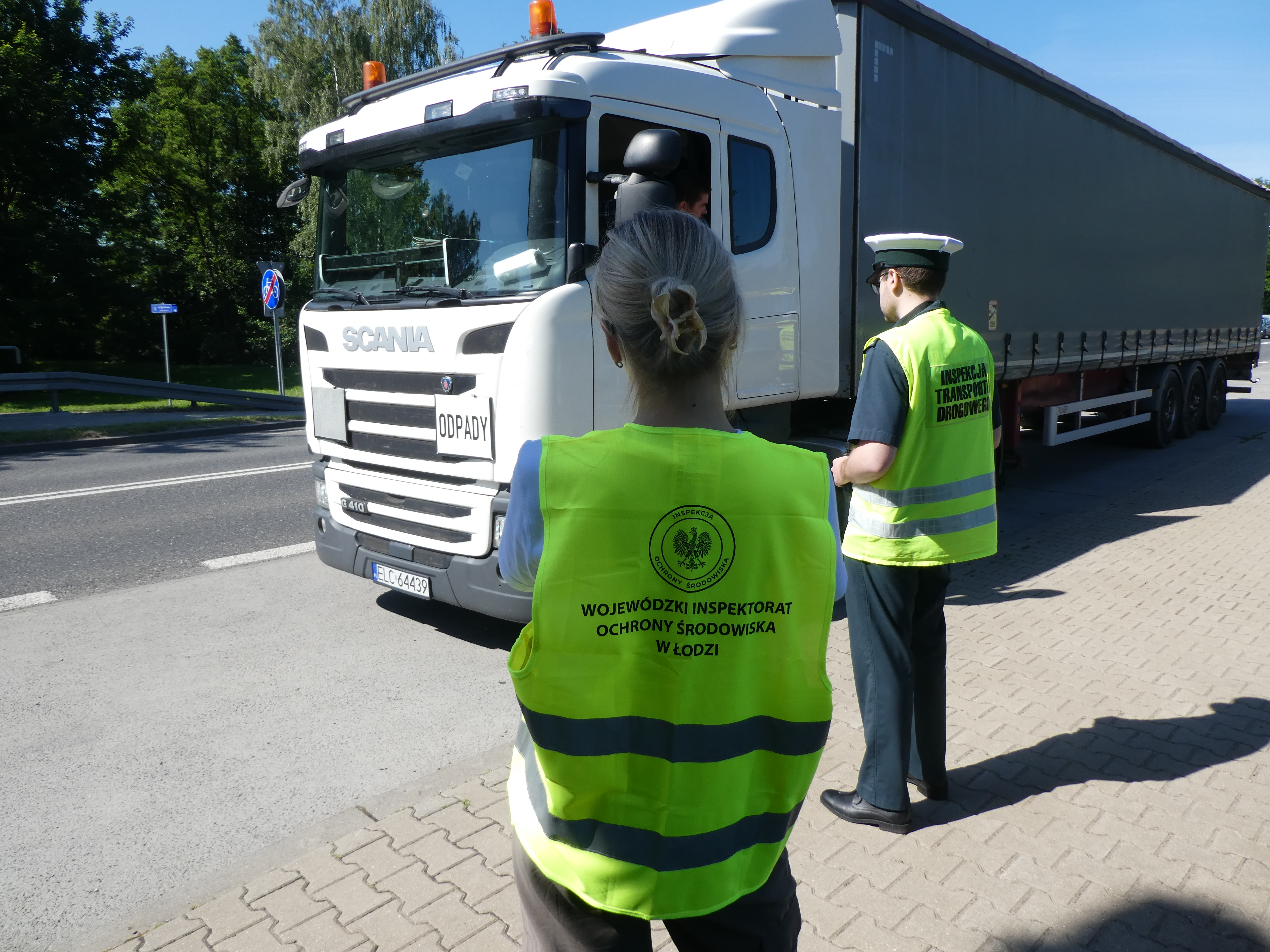 Inspektorka Ochrony Środowiska i Inspektor Transportu Drogowego kontrolują pojazd marki scania